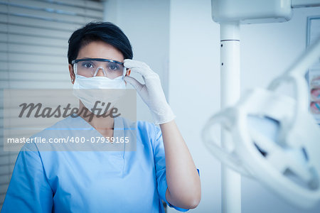 Portrait of female dentist wearing surgical mask and safety glasses