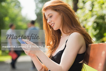 Pretty student sending a text outside at the university