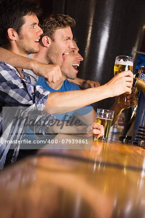 Happy friends catching up over pints in a bar