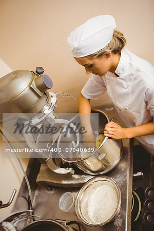 Baker using large mixer to mix dough in a commercial kitchen