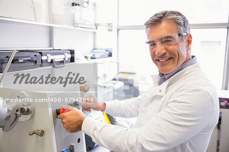 Senior pharmacist using machine to make medicine at the laboratory