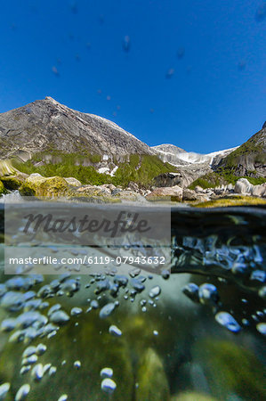 Above and below view of ice melt waterfall cascading down in Svartisen National Park, Melfjord, Nordfjord, Norway, Scandinavia, Europe