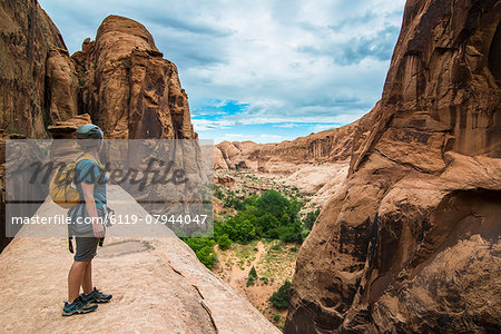 Woman standing on a giant arch near Moab, Utah, United States of America, North America