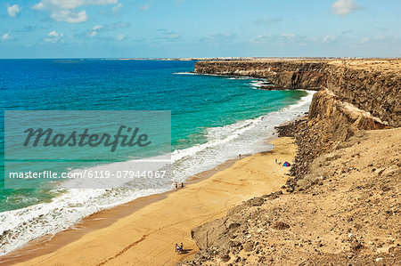 Volcanic rock headland and sandy beach south of this village on the north west coast, El Cotillo, Fuerteventura, Canary Islands, Spain, Atlantic, Europe