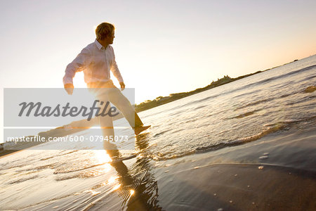 Man skipping rocks in the water at Bailey's Beach on an autumn morning, Newport, Rhode Island, USA Man skipping rocks in the water at Bailey's Beach on an autumn morning, Newport, Rhode Island, USA