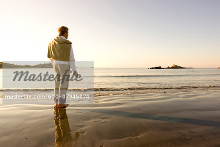 A man pauses while skipping rocks into the water at Bailey's Beach on an autumn morning, Newport, Rhode Island, USA. A man pauses while skipping rocks into the water at Bailey's Beach on an autumn morning, Newport, Rhode Island, USA.