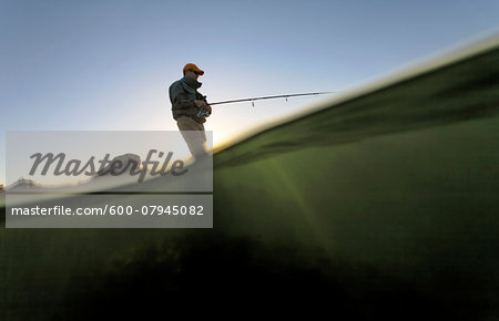 Low angle view of man fishing along the coast of Rhode Island, USA Low angle view of man fishing along the coast of Rhode Island, USA