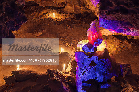 Big Red and yellow crysta in cave with candle light on background. Mlynky Cave, Ukraine