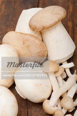 bunch of fresh wild mushrooms on a rustic wood table