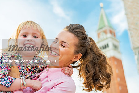 Portrait of happy mother and baby against campanile di san marco in venice, italy