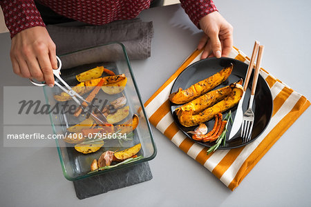 Closeup on young housewife serving baked pumpkin