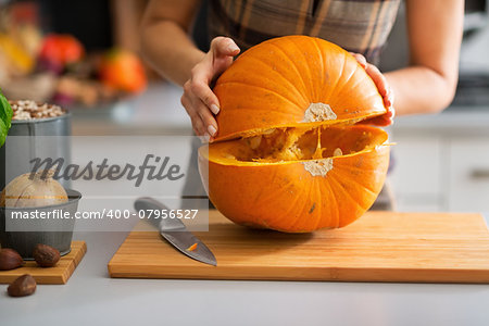 Closeup on young housewife cutting pumpkin