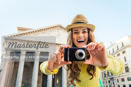 Smiling young woman taking photo in front of pantheon in rome, italy