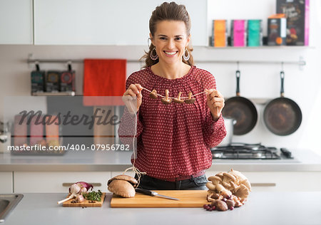 Young housewife drying mushrooms