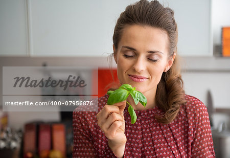 Young housewife enjoying fresh basil