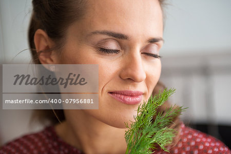 Portrait of young housewife enjoying fresh dill