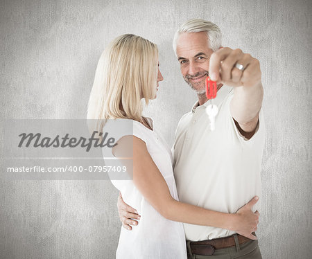 Happy couple showing their new house key against weathered surface