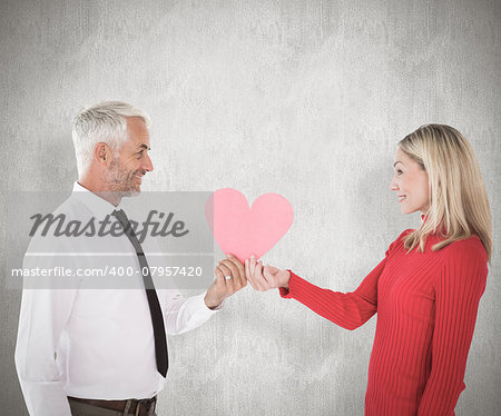 Handsome man getting a heart card form wife against weathered surface