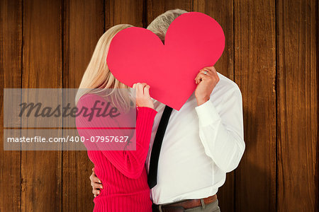 Handsome man getting a heart card form wife against wooden planks