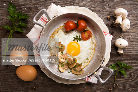 Fried egg with mushrooms and tomatoes