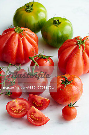 Various types of tomatoes with drops of water