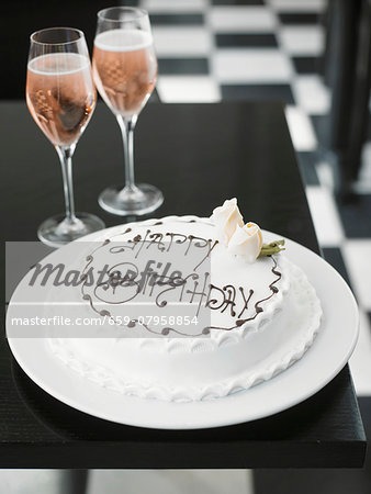 A white birthday cake and rosé champagne