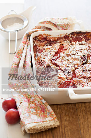 Freshly baked clafoutis with plums in a baking dish