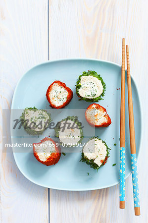 Slices of toast roulade with herb and pepper coatings filled with herb cream cheese