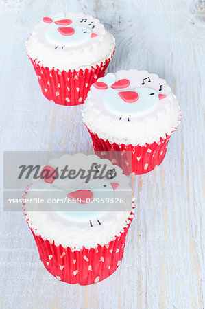 Raspberry and chocolate cupcakes decorated with singing birds