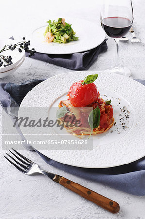 Pasta with tomatoes and basil served with a glass of red wine