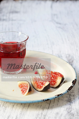 A glass of red wine and fresh figs on a plate