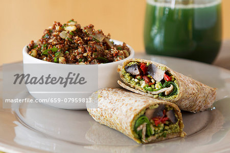 Wholemeal wraps filled with portobello mushrooms, pesto, dried tomatoes and courgettes next to a bowl of quinoa with cabbage and coconut milk