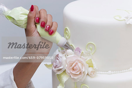 A wedding cake being decorated
