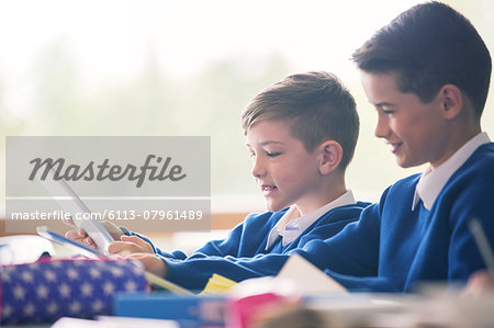 Primary school boys with digital tablets in classroom