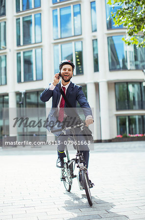 Businessman talking on cell phone on bicycle