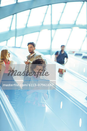 Woman using digital tablet on escalator