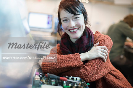 Computer Repair Shop. A woman smiling and leaning on a workshopcounter.