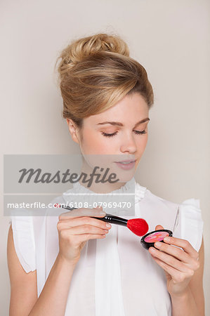 Beautiful woman holding make-up brush