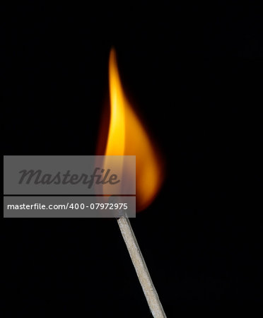 Build a fire. Lighted match on a black background
