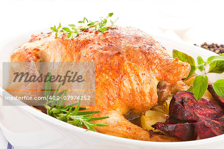 Luxurious grilled chicken with fresh herbs in baking dish prepared for eating.