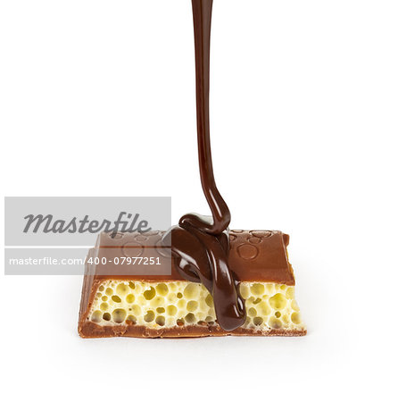 dark chocolate is poured onto a piece of porous chocolate on a white background