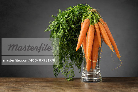 A bunch of fresh carrots in glass vase