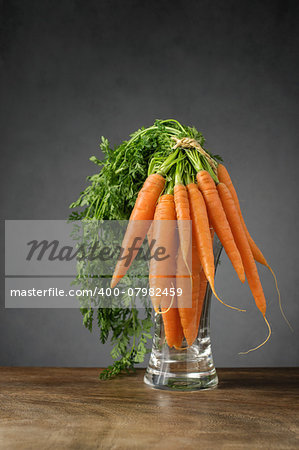 A bunch of fresh carrots in glass vase