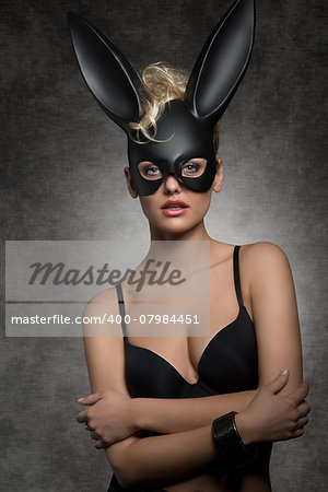 sexy blonde woman with black bra posing in gothic easter portrait with stylish dark bunny mask