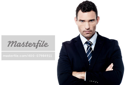 Serious businessman standing with arms folded