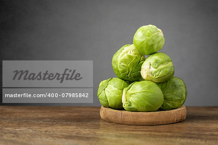 A heap of fresh brussels sprouts on wooden table