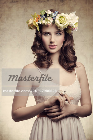 Beautiful, brunette woman with colorful makeup, wreath of flowers on head, little bird on her finger.