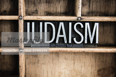 The word "JUDAISM" written in vintage metal letterpress type in a wooden drawer with dividers.