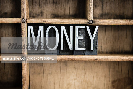 The word "MONEY" written in vintage metal letterpress type in a wooden drawer with dividers.