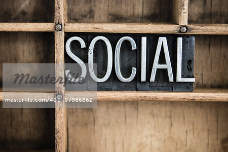 The word "SOCIAL" written in vintage metal letterpress type in a wooden drawer with dividers.